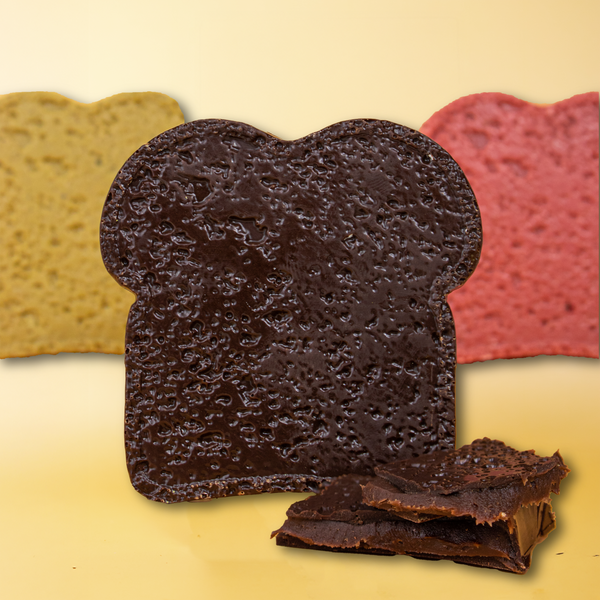 Dunkle Mini-Schokolade in Brot-Form, aufgebrochene Stücke davor zeigen die cremige Schoko-Mousse-Füllung.