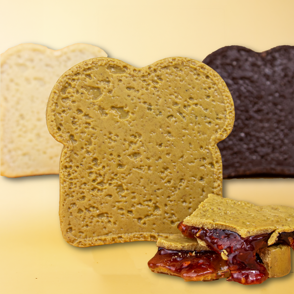 Pistazien-Mini-Schokolade in Brot-Form, aufgebrochene Stücke davor zeigen die Himbeer-Gel-Füllung.